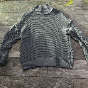 Long sleeved grey sweater with long neck.